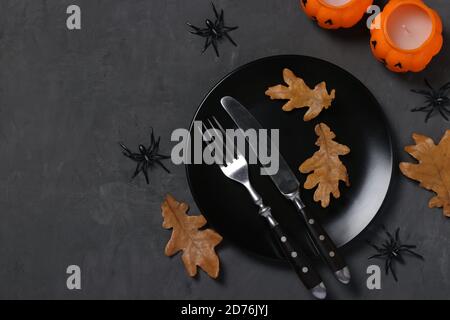 Halloween Tischdekor ist mit Kürbis förmigen Kerzen, Spinnen und Horror Party Dekor auf schwarzem Tisch dekoriert. Speicherplatz kopieren. Stockfoto