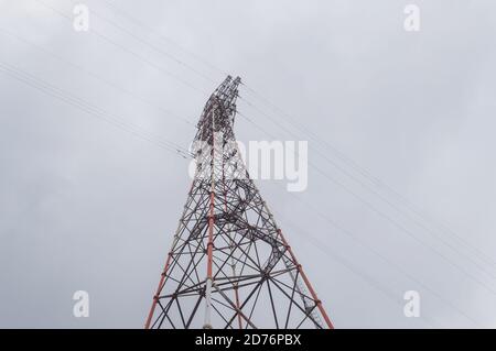 Ansicht von unten auf Netzleitungsunterstützung steigt oben in Himmel Stockfoto