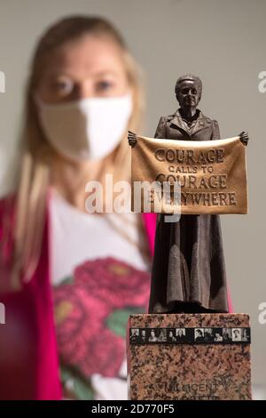 Ein Mitarbeiter sieht eine Maquette der "Courage Calls to Courage Everywhere"-Statue der Suffragette Millicent Fawcett von Gillian Wearing in einer Vorschau auf "Unfinished Business: The Fight for Women's Rights", eine neue Ausstellung über Frauenrechte in der British Library in London. Stockfoto