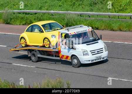 Gelber VW Volkswagen Käfer auf Autotransporter 24 Stunden Pannendienst kommerzielle Pannenbergung; Transportfahrzeuge, LKW, Transport, LKW, Frachtführer, Ford 90 T30 Fahrzeug, europäischer Nutzverkehr, Industrie, M6 in Manchester, Großbritannien Stockfoto