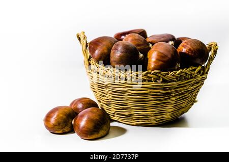 Kastanien im Weidenkorb auf weißem Hintergrund Stockfoto