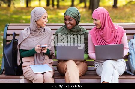 Muslimische Studentinnen Mit Laptops Und Smartphone Gemeinsam Draußen Lernen Stockfoto