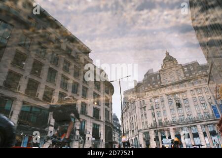 Spiegelung von Gebäuden im Londoner Finanzviertel (King William Street, nahe der U-Bahnstation Monument) in einer Pfütze. Stockfoto