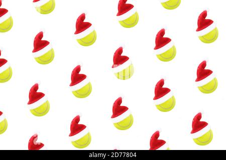Weihnachtsmütze auf Tennisball Muster auf weißem Schnee Hintergrund. Frohe Weihnachten und Neujahrskonzept mit Tennisbällen. Gelb grüne Farbe Tennisbälle, Sport Lifestyle. Isoliert, Stockfoto