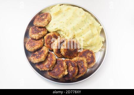 Kartoffelpüree und Linsenschnitzel Teller auf weiß Stockfoto