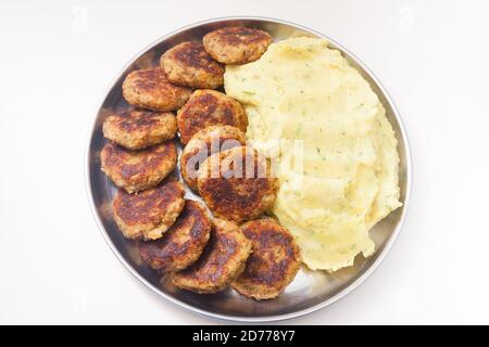Teller mit Kartoffelpüree und Linsenschnitzel an den Seiten Stockfoto