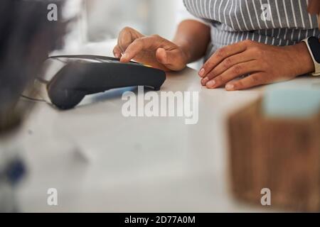 Shop-Mitarbeiter akzeptieren Zahlung über Geld-Terminal Stockfoto