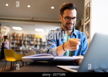 Junge Studentin mit Laptop studiert in der Universitätsbibliothek Stockfoto