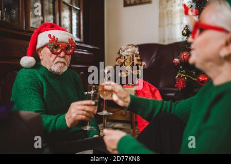 Seniorenpaar zu Hause mit einer Weihnachtsfeier auf einem Videoanruf Stockfoto
