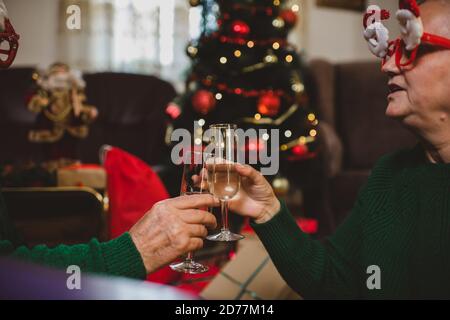 Seniorenpaar zu Hause mit einer Weihnachtsfeier auf einem Videoanruf Stockfoto