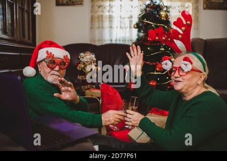 Seniorenpaar zu Hause mit einer Weihnachtsfeier auf einem Videoanruf Stockfoto