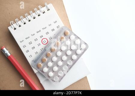 Geburtenkontrolle Pillen, Kalender und Notizblock auf dem Tisch Stockfoto