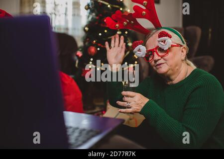 Ältere Frau zu Hause mit einer Weihnachtsfeier auf einem Videoanruf Stockfoto