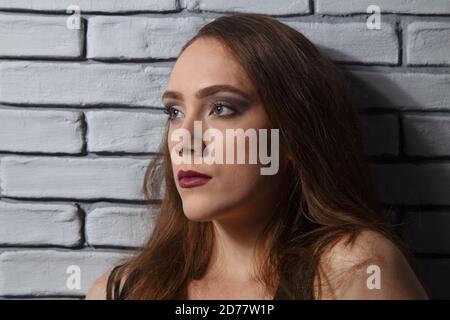 Portrait der Frau mit hellen Make-up auf Backstein Wand Hintergrund Stockfoto