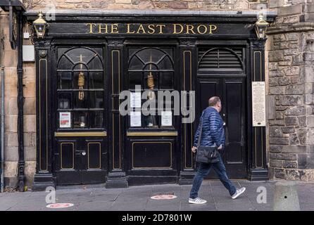 Edinburgh, Großbritannien. 21. Oktober 2020 im Bild: Der schottische erste Minister Nicola Sturgeon hat angeordnet, dass Pubs im Central Belt geschlossen bleiben, bis am 2. November 2020 neue 5-stufige Beschränkungen eingeführt werden. Ein Passant geht am Last Drop Pub in Edinburghs Grassmarket vorbei. Kredit: Rich Dyson/Alamy Live Nachrichten Stockfoto