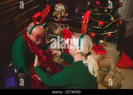 Seniorenpaar zu Hause mit einer Weihnachtsfeier auf einem Videoanruf Stockfoto