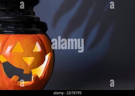 Halloween, Horror und Mystik Konzept. Nahaufnahme von Kürbis mit einem geschnitzten Gesicht und einem finsteren Schatten von Tentakeln, die im Hintergrund wehten Stockfoto