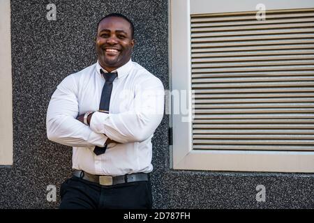 Porträt eines glücklichen afroamerikanischen Geschäftsmannes, der die Kamera anschaut und lächelt. Stockfoto