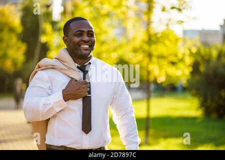 Porträt eines glücklichen afroamerikanischen Geschäftsmannes, der im Park läuft. Stockfoto