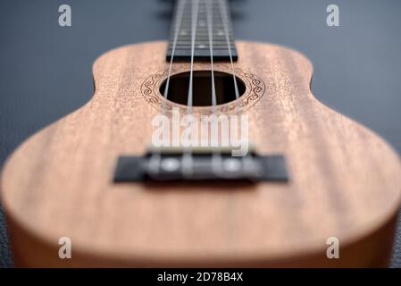 Braune Ukulele auf schwarzem Hintergrund mit flacher Tiefe des Feldes Stockfoto