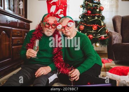 Seniorenpaar zu Hause mit einer Weihnachtsfeier auf einem Videoanruf Stockfoto