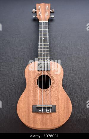 Eine braune Sopranukulele auf schwarzem Hintergrund Stockfoto