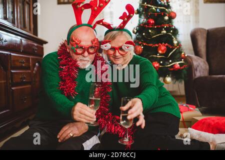 Seniorenpaar zu Hause mit einer Weihnachtsfeier auf einem Videoanruf Stockfoto