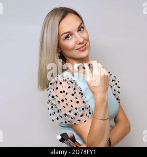 Portrait der schönen Frau mit Make-up-Pinsel Blick auf die Kamera Stockfoto