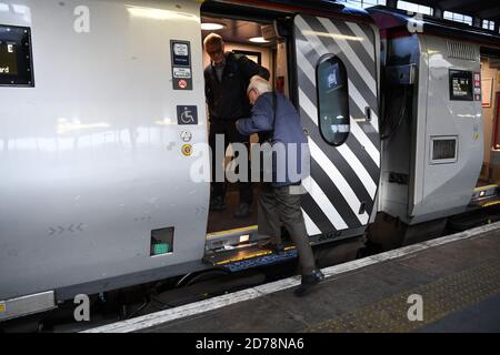Mann hilft älteren Herrn an Bord Virgin Zug in Euston London. Stockfoto