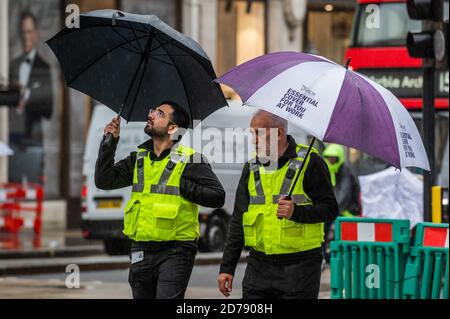London, Großbritannien. Oktober 2020. Regenschirme, die eine 'essentielle Bucht' bieten, dämpfen die Stimmung in der Oxford Street. Schwierige Zeiten für Einzelhändler wie die als der Regen fällt und Coronavirus Beschränkungen beginnen, wieder zu erhöhen. Kredit: Guy Bell/Alamy Live Nachrichten Stockfoto