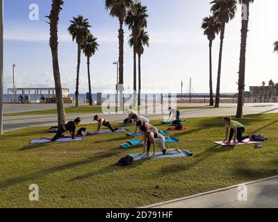 Yoga im Freien. Gruppe von Menschen, die Übungen mit einem Ausbilder machen. Stockfoto