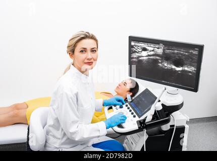 Portrait der Frau Ultraschall Arzt während Ultraschall-Verfahren für eine Junge Patientin in einer modernen Klinik Stockfoto