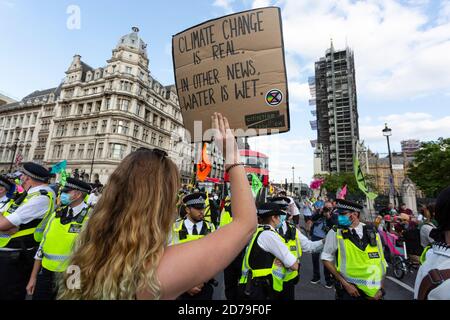 Protesterin hält Plakat vor der Polizei, Extinction Rebellion Demonstration, Parliament Square, London, 10. September 2020 Stockfoto