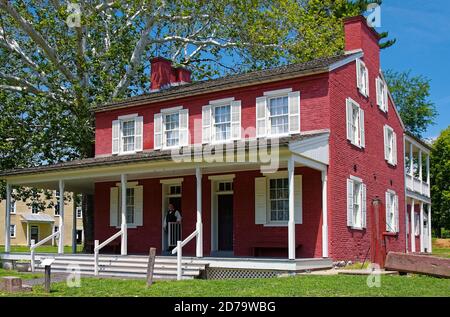 Landis Valley House Hotel, 1856, rot lackierte Ziegel, weiße Fensterläden & trimmen, zwei Eingangstüren, Veranda, Wasserpumpe, Trog, altes Gebäude, Landis Valley Stockfoto