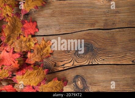 Bunte Herbstblätter auf braunem Holzgrund. Stockfoto