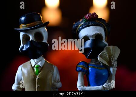 Plastikschädel zum Anbieten der Toten mit einer Gesichtsmaske Für covid-19 Stockfoto