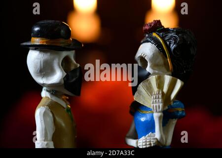 Plastikschädel zum Anbieten der Toten mit einer Gesichtsmaske Für covid-19 Stockfoto