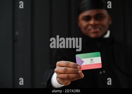 Afrikanischer Mann tragen schwarz durag halten Äquatorialguinea Flagge bei der Hand isoliert dunklen Hintergrund. Stockfoto