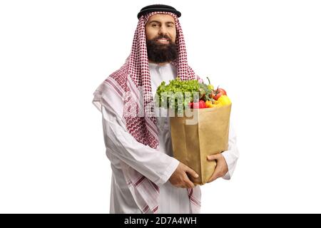 Arabischer Mann in einem Thobe mit einer Lebensmitteltasche stehend Und lächelnd isoliert auf weißem Hintergrund Stockfoto