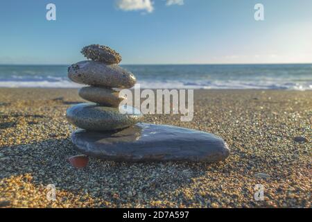 Pyramide der Steine auf einem Sandstrand gegen die Meer Stockfoto