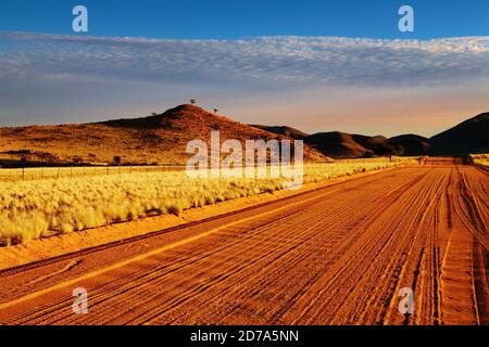 Straße in Kalahari Wüste bei Sonnenuntergang, Namibia Stockfoto