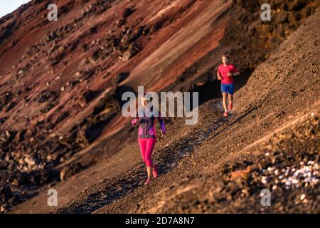 Sportler auf dem Trail trainieren im Sommer gemeinsam im Freien bei Sonnenuntergang Cardio-Training. Nachmittags paar Training laufen in der Berglandschaft Stockfoto