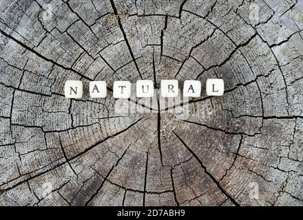Wort natürlich aus Holz Alphabet Perlen auf einem Baumstumpf Oberfläche im Wald. Stockfoto
