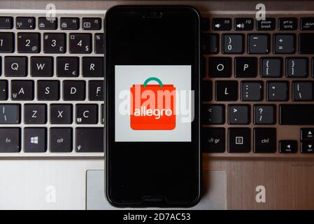 In dieser Abbildung ist ein Allegro-Logo auf einem Smartphone mit einer Laptop-Tastatur im Hintergrund zu sehen. Stockfoto