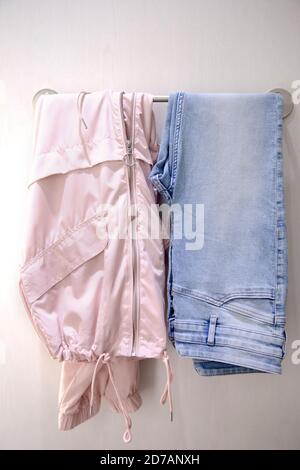 Minimalismus Modekonzept. Modische rosa Regenjacke und Jeans in der Umkleidezimmer. Stockfoto