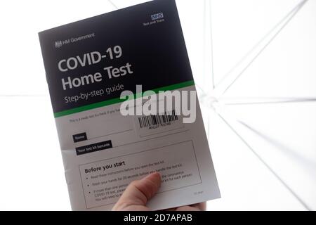 Covid-19 / Gesundheit/ Pandemie / Testkonzept für zu Hause - hochauflösende Nahaufnahme einer Person, die einen Covid-19 Home Test Guide hält. Weißer Hintergrund. Stockfoto