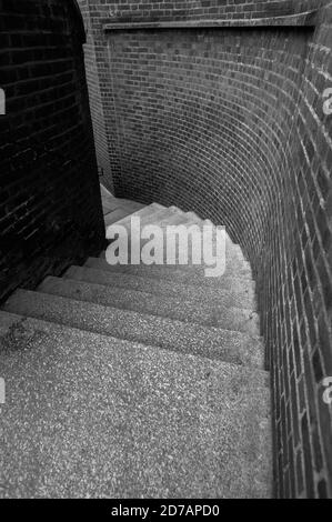 Schwarz-weiß monochromes Bild von Blick auf einige verwinkelte Straßentreppen nach rechts in einer Gasse. Stockfoto