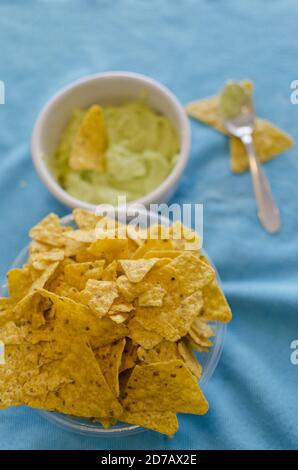 Nahaufnahme einer leckeren Nacho-Schale und einer Guacamole In den Hintergrund tauchen Stockfoto