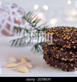 Advent- und Weihnachtsstimmung, Honigkuchen gestapelt, wunderschön dekoriert auf einem weißen Holztisch im Hintergrund eine weiße weihnachtskugel Stockfoto