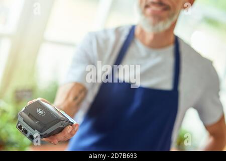 Zahlterminal in männlicher Hand Stockfoto